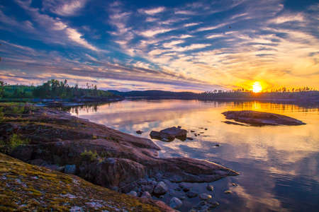 The nature of Finland. Sunset on the shore of the lake. Coastline. Evening clouds. Nature of the North. Summer in Finland.の写真素材