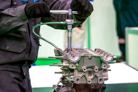 Locksmith Car service. Engine repair. An employee car service makes analysis of the engine. Motor cars disassembled.の写真素材