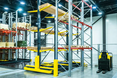 Forklift on the background of boxes. Stock. Loading goods. Cargo storage. Logistics. Forklift on the background of racks. Shelves in stock. Tiered metal shelving. Warehouse services.の写真素材