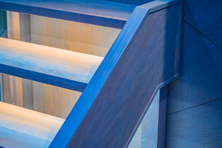 Illuminated wooden staircase. Lighting residential. Interior Design. Fragment of the house.の写真素材