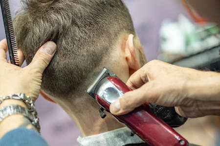 Barber is working. The process of men's model haircut. Making edging haircuts. Male salon hairdresser. Barber hair salon. Grooming.の写真素材