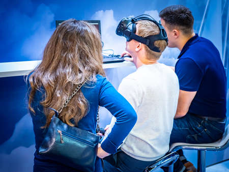 Virtual simulator. People are immersed in a viral reality. Helmet-glasses of virtual reality. Electronics. Electronic headset. Computer immersion. IT technology. Computer simulation and imitation.の写真素材