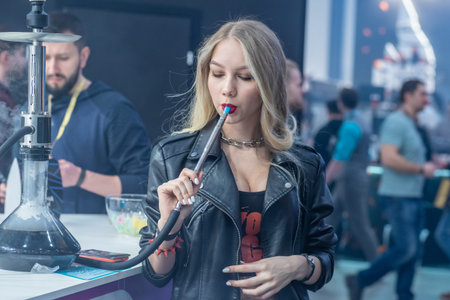 Woman smokes a hookah. Smoke. The girl tastes tobacco. Smoking accessories. Tabaka. Hookah Club...