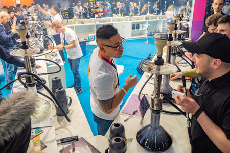 A man tastes the scent of hookah tobacco. Smoke. Smoking accessories. Tabaka. Hookah Club Show. Exhibition of hookahs. 9.3.2019. Russia. Saint Petersburgのeditorial素材