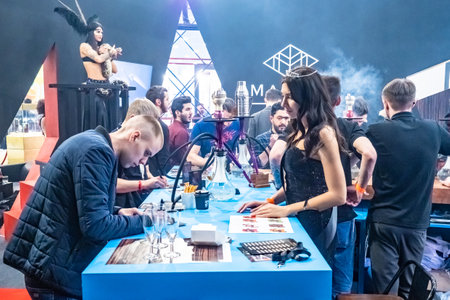 People choose hookah. Smoke. People looking at samples of tobacco. Smoking accessories. Tabaka. Hookah Club Show. Exhibition of hookahs. 9.3.2019. Russia. Saint Petersburgのeditorial素材