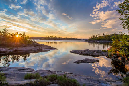 Reflection of the sky in the water. Dawn. Wildlife of Karelia. Ladoga lake. Travel to Russia. Republic of Karelia. Islands on the lake. Northern nature.の写真素材