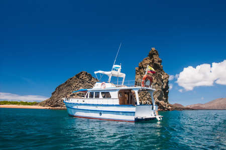 Galapagos. Ecuador. Yacht on the water near the rocks. Yachting. Boat trip on the Galapagos Islands. Travel to Ecuador. Pinnacle rock on bartolome islandの写真素材