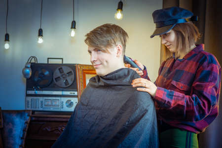 The girl is cutting the guy. A haircut. Hair clipper.の写真素材
