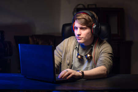 Hacker. A young man works at the computer. A man at the computer. Hacking personal data.の写真素材