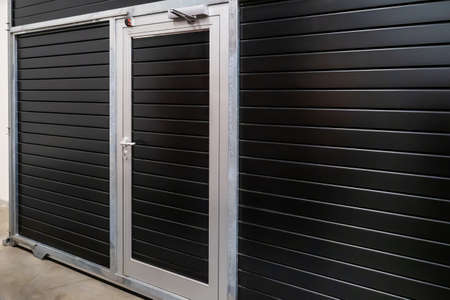 Industrial overhead sectional doors. Sectional garage doors. Garage. Entry to production. Gate with a door.の写真素材