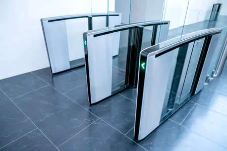 Turnstiles. Checkpoint. Automatic access control. Access system in the building. Automatic turnstile with sliding doors to control the flow of people. Entrance hall with turnstileの写真素材