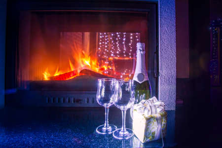 Fireplace with fire. Approaching the holiday of Christmas. New Year's celebration. Glasses stand by the fireplace.の写真素材