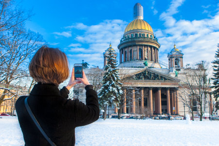The girl takes pictures of the museums of St. Petersburg. Saint Isaac Cathedral. Architecture of Russia. The tourist photographs Petersburg. Saint Petersburg. 03/20/2018のeditorial素材