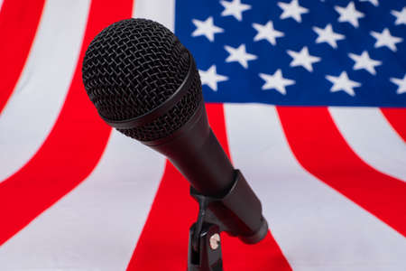 Microphone close - up on the background of the USA flag. Election debates in America. Election of the President of the United States. Report from the American Presidential election.の写真素材
