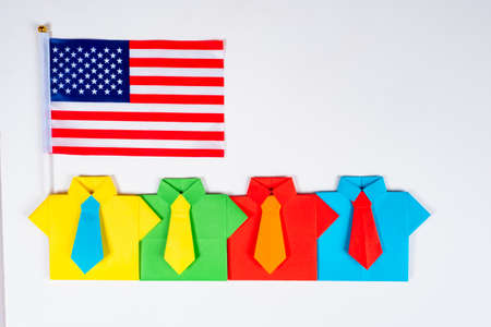Staff of an American firm. Employment in the United States. Origami office suits and American flag. A vivid conception of the team with the flag of the United States.の写真素材