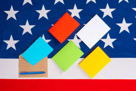 Colored paper, an envelope, and an American flag. American Post. Correspondence with Americans. Mail advertising in the USA. A public opinion poll of Americans.の写真素材