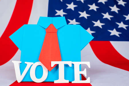 A call to vote in the US Presidential election. Origami man and American flag. Election race. Election campaign 2020 in the United States.の写真素材