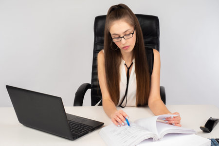 A long-haired girl with glasses looks through financial documents. Auditor check. financial...