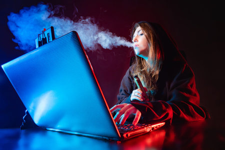 A girl blogger smokes a VAPE in front of the screen. The girl is broadcasting and Smoking an...