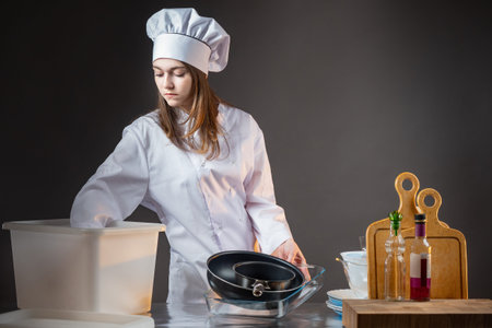 The discontinuance of the restaurant. Sad girl chef collects dishes. Bankruptcy of the restaurant. A...