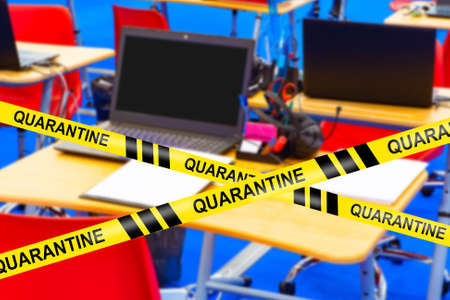 The school is closed for quarantine. An empty computer lab with a background of restrictive tapes labeled Quarantine. Restrictions are related to the coronavirus. Self-limiting mode due to Covid-19.の写真素材