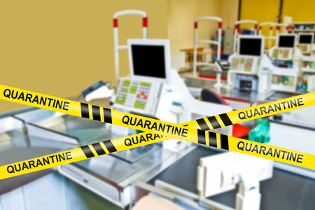 The store's cash registers are marked with restrictive tapes and Quarantine labels. A coronavirus...