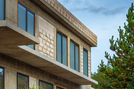 A foam block house is being built. A house under construction near the pines. Construction of cottages on individual projects. A fragment of a stone building under construction.の写真素材