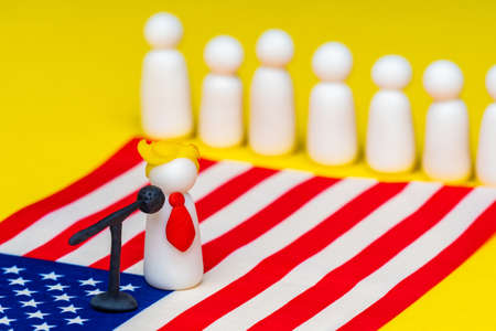 Concept of the US Presidential election. Symbolic figure of  and the American flag. An American politician gives a speech to voters. USA elections 2020.の写真素材