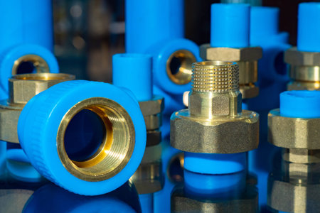 Plumbing products with a blue finish. Plumbing adapters and connectors on the table. Threaded...