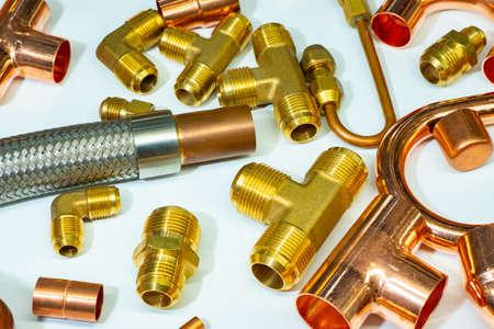 Scattering of various brass sanitary products. Tees, connectors, nipples.Threaded fittings and couplings. Bright background of plumbing details. Connecting elements for water supply.の写真素材