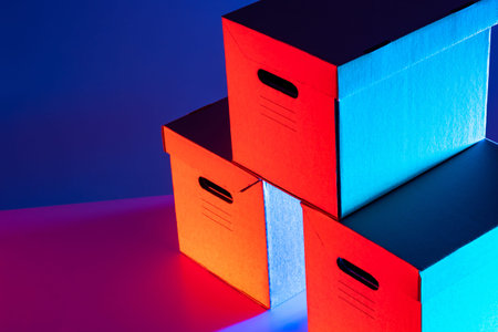 Cardboard boxes with handles for moving. Cardboard boxes are brightly lit. Delivery of goods from...