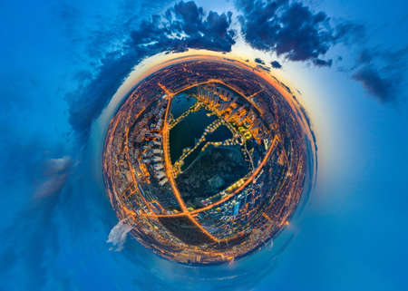 Aerial photography of the city. Evening city as a planet. Night illumination of the planet Earth. The urban area is perceived as a separate planet. Life in the Universe. The city from a drone.の写真素材