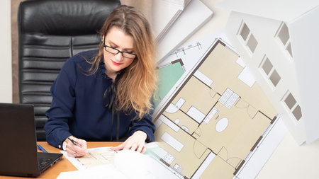 The architect is developing a project for a new house. The girl works in an architectural and...