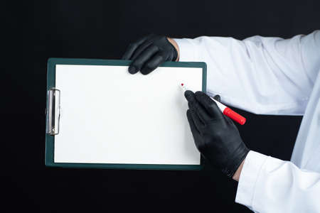 Medical information. A man in a white coat is holding a tablet and a marker. A placard with a place for the text in the hands of a doctor. New treatment.の写真素材
