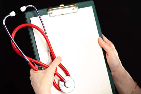A tablet with a blank sheet of paper and a close-up stethoscope. Concept of medical information. The communication of medical data. Space for text. Medical advertising.の写真素材