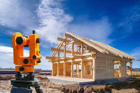 Surveyor at the construction site. Map equipment. Geodetic works in construction. Building tool. Geodetic equipment. Geodesy. Construction of a country house.の写真素材
