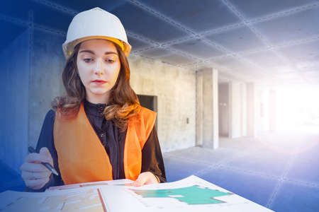 Construction engineer. The girl works as an engineer in construction. A woman with construction documentation checks the progress of work. Supervision of work.の写真素材