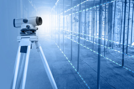 Surveyor. Projection of a geodetic survey in a building under construction. Theodolite on a tripod is installed in a house under construction. Geodetic instrument. Angular measurement.の写真素材