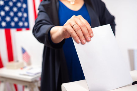 Elections in the United States. Hand with a ballot close-up. Voting woman on the background of the...