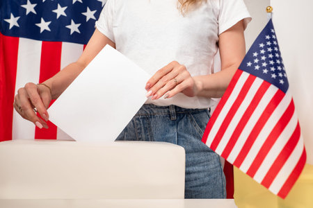 Election campaign in the United States. The girl puts the ballot in the basket for voting. An...