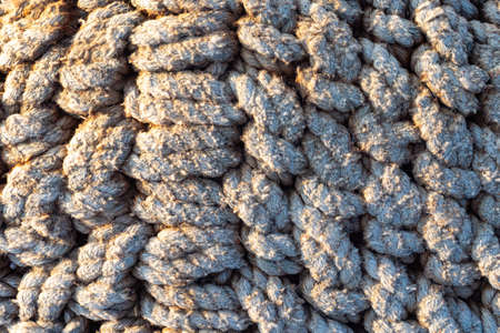 Background of old ropes. Thick ropes are woven together. Texture of thick ropes. Warm background of slings.の写真素材