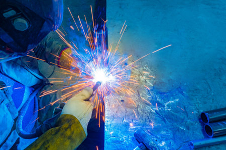 Sparks from welding. Welding production. Welder at work. A man is welding metal parts. Metalworking....
