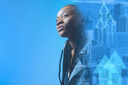 The panorama of the city flows into the portrait of a dark-skinned girl. Blue background with city and African-American woman. Place for text. Dark-skinned girl with braids, city and arrows.の写真素材