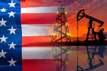 Oil production in the United States. Oil platform on the background of the American flag. American flag and oil rig. US fuel market. Natural resource extraction in America.の写真素材