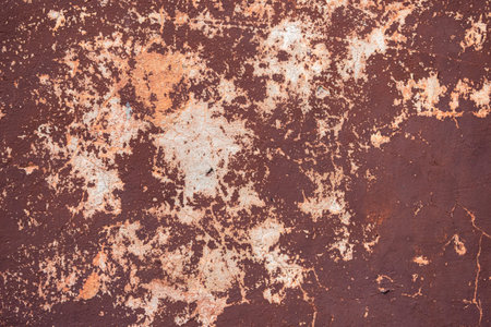 An old cracked brown wall. Background from the wall of an old house. Brown construction texture. The...