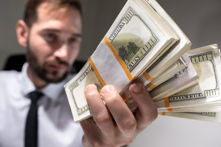 A man with bundles of dollars in his hands. A lot of money close-up in the hands of a man. Passive...