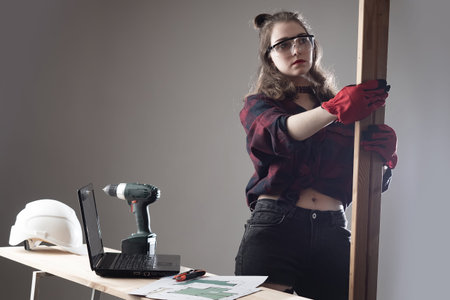 Manufacturing of furniture to order. A girl in a carpenter shop. Furniture of a new house. Making...