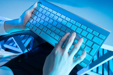 Keyboard in the hands of a person close-up. A person uses a laptop computer at home. Business, working from home, learning online. The journalist writes a new article. A blogger writes a post.の写真素材