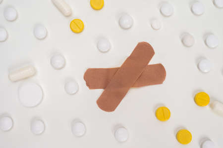 First medic aid. Medical concept. Medical care. Patch and pills on a white table. Treating people. Medical assistance. Light medicinal background.の写真素材