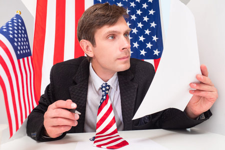 A strict American official. Checking resumes for positions in the USA. A man with an American tie...